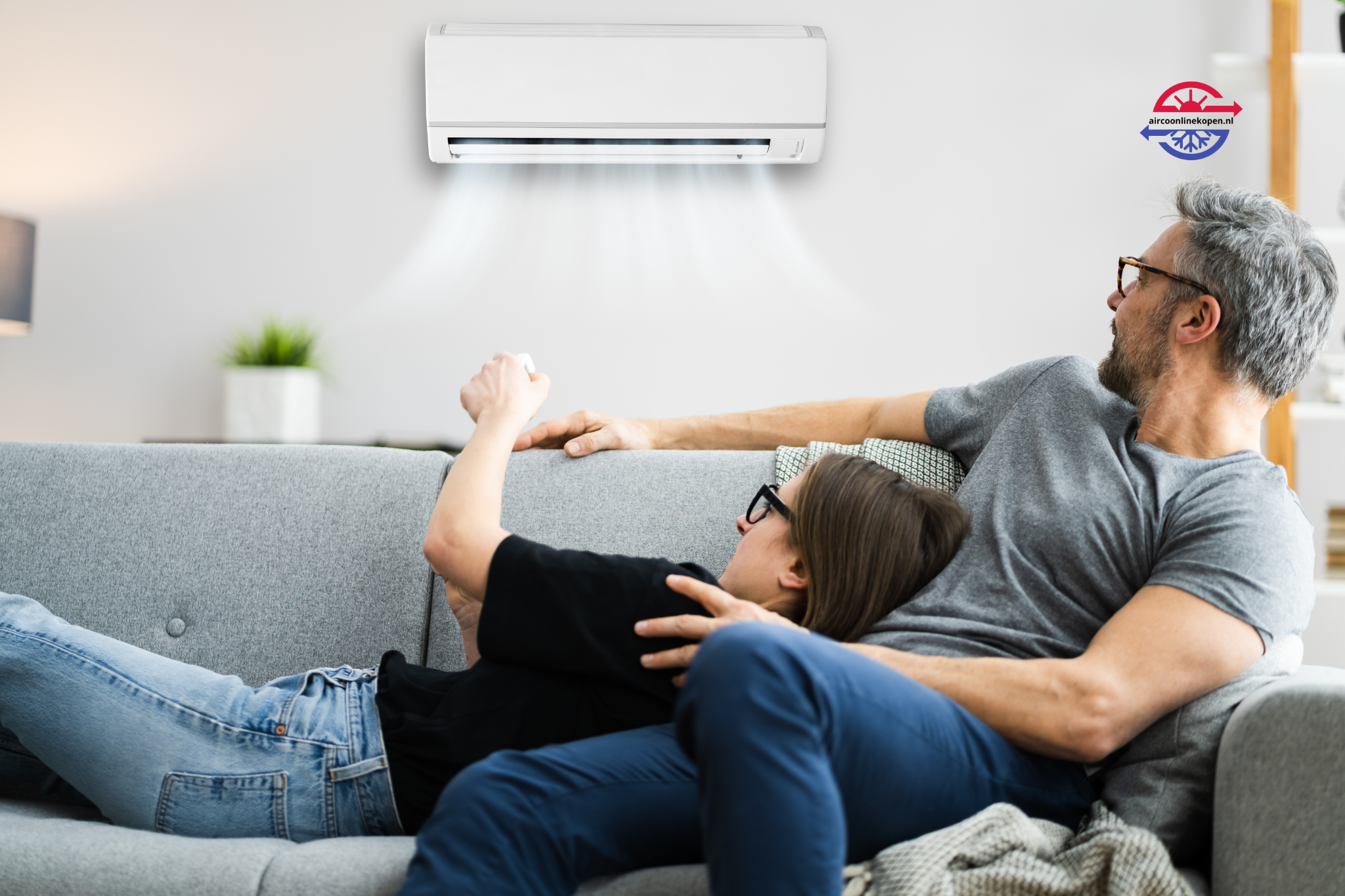 Koppel ontspant onder een werkende airco in de woonkamer dankzij installatie door Aircoonlinekopen.nl