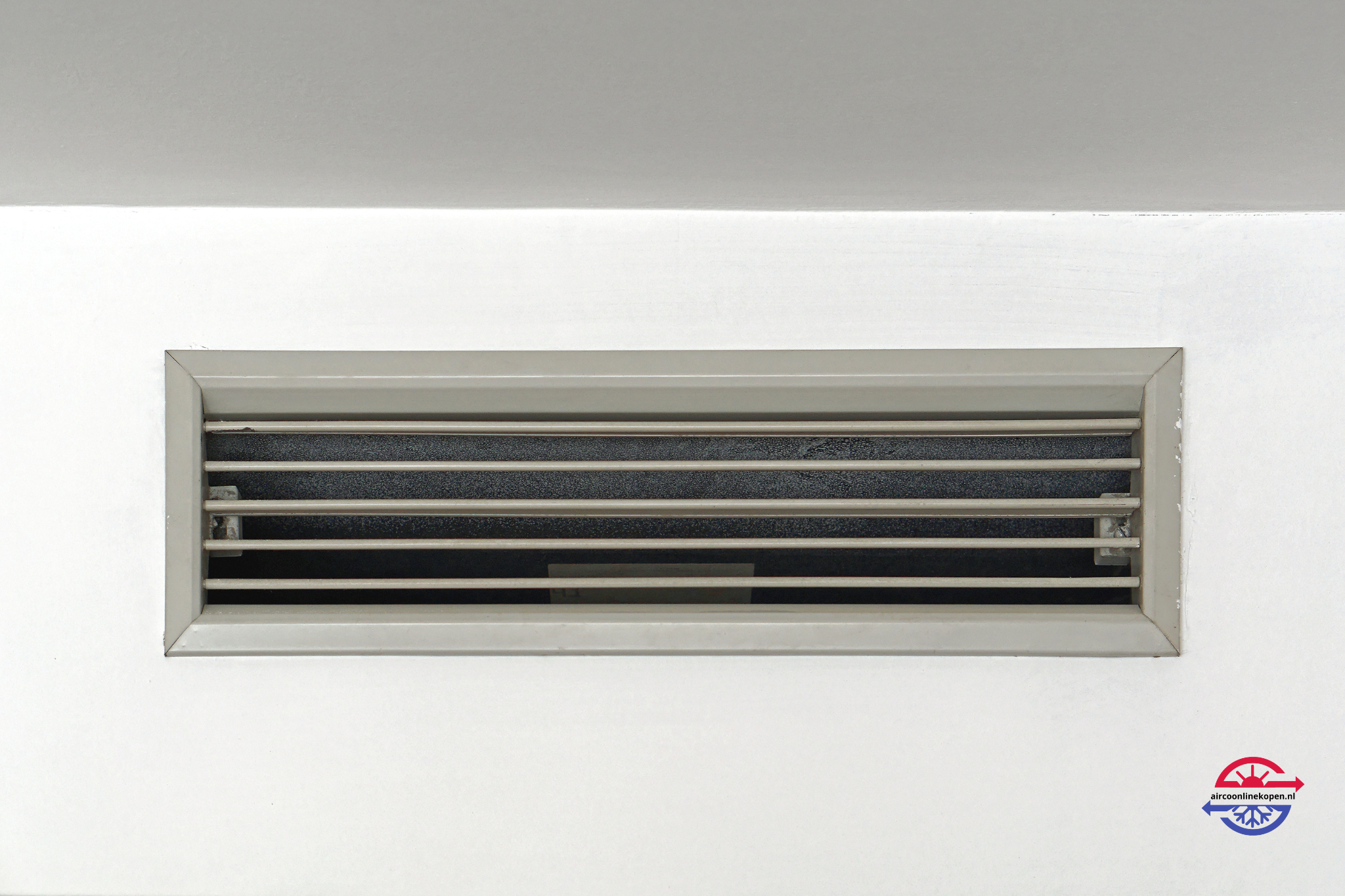 Uitblaasrooster van een kanaalairco in een wit plafond