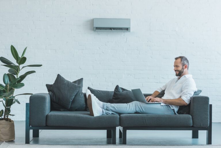 Man ligt ontspannen op de bank dankzij werkende airco via Aircoonlinekopen.nl